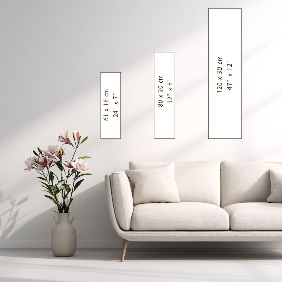 White sofa with a vase of flowers and framed pictures on a light gray wall.
