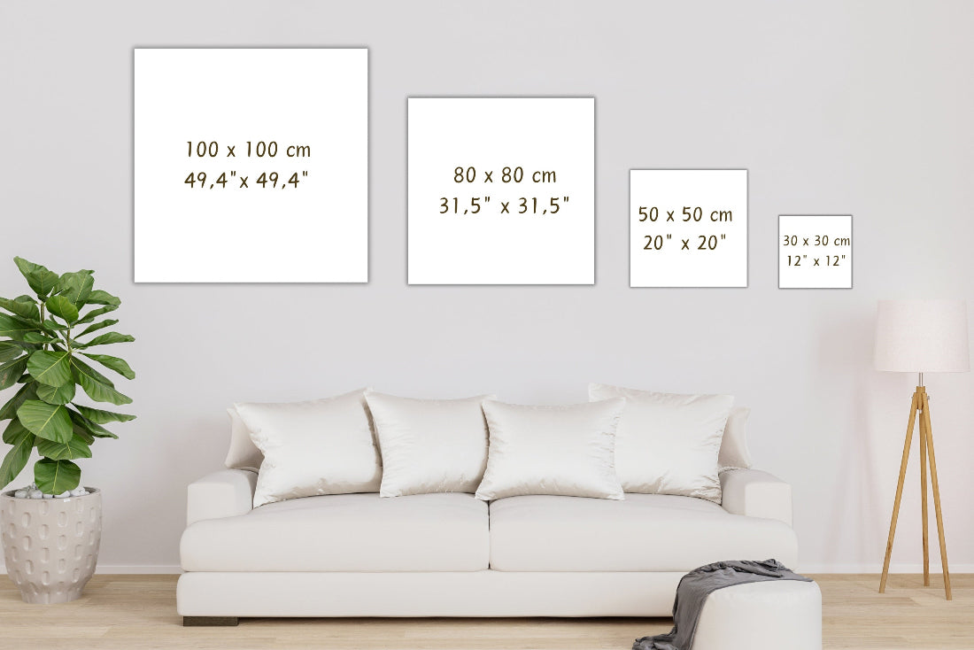 White frames of different sizes displayed on a wall above a sofa.