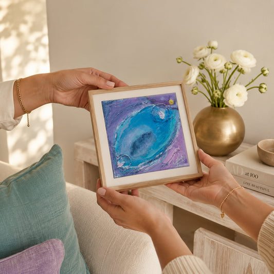 Two hands passing Enchanting Energy 3 in a natural oak frame