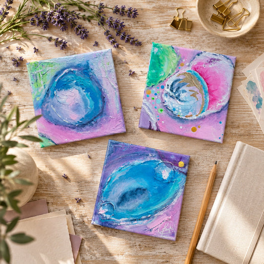 Three original abstract paintings laid on wood with blue, pink and purple details, lavender and gold clips