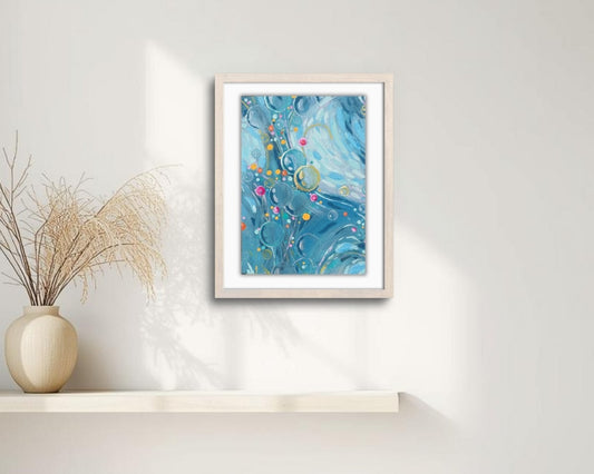 Framed abstract artwork on a white wall with a vase and branches on a shelf.