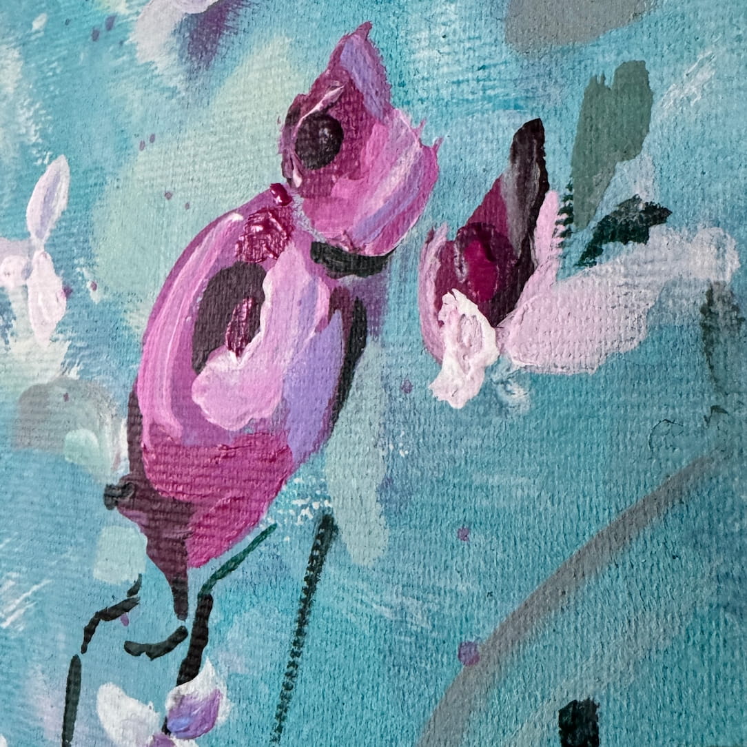 Close-up of a painted floral scene with pink and purple blossoms on a textured light blue canvas.