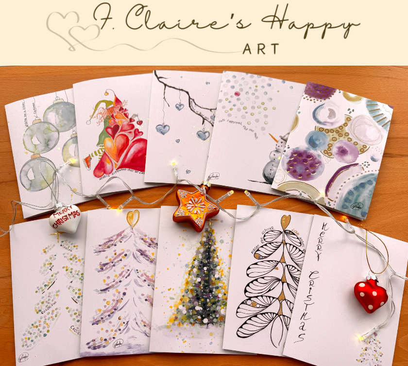 Collection of Christmas-themed greeting cards on a wooden surface with 'J. Claire's Happy Art' branding.