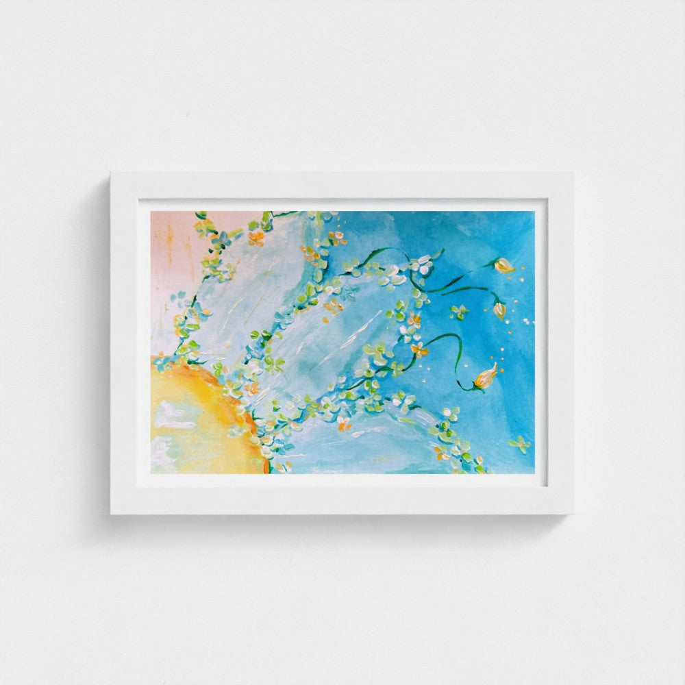 A framed abstract wall art print featuring a vibrant blue sky with green leafy vines, small yellow flowers, and a soft yellow sun on the left, housed in a clean white frame and mounted on a light gray wall.