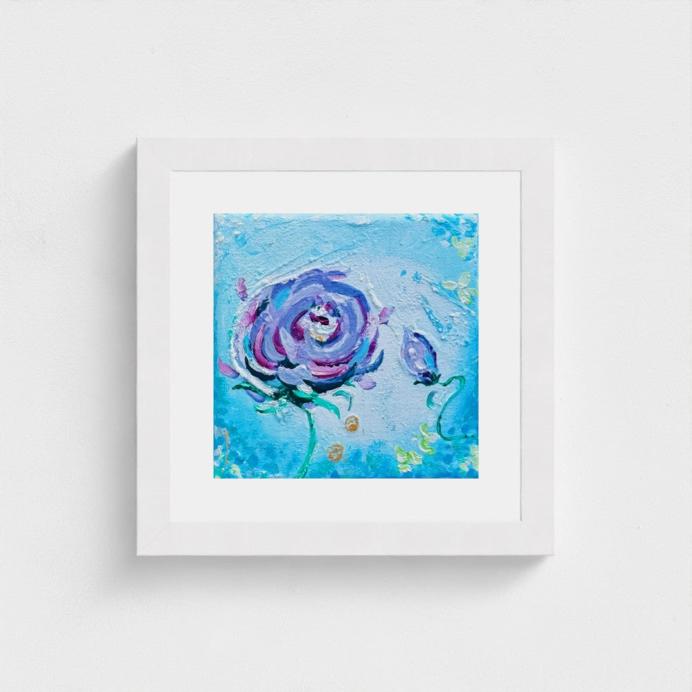 Mini Miracle in a white frame with a purple rose on blue
